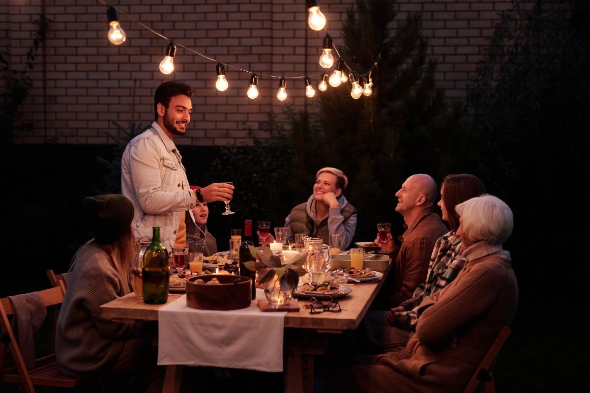 Dîner de célébration en plein air sous des guirlandes lumineuses