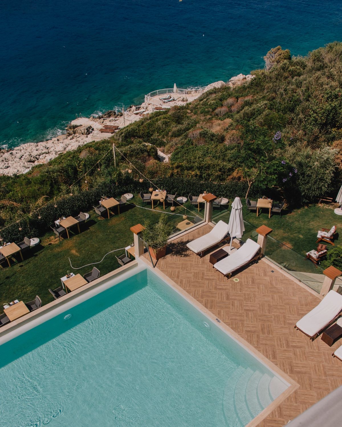 Hôtel avec piscine et transats au bord de l'eau, vu du ciel